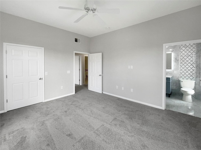 unfurnished bedroom with dark colored carpet, ensuite bath, and ceiling fan