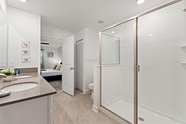 bathroom with a shower with shower door, double vanity, tile patterned floors, and toilet