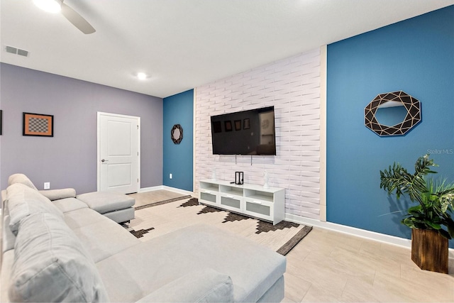 living room featuring brick wall, light tile patterned floors, and ceiling fan