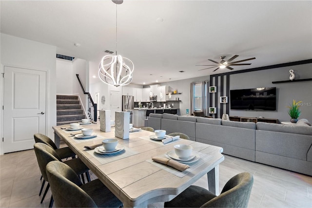 tiled dining area featuring ceiling fan with notable chandelier