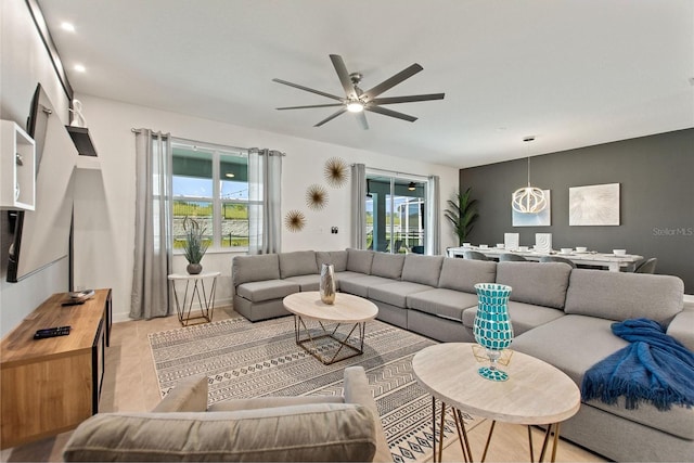 living room featuring light hardwood / wood-style flooring, ceiling fan, and a wealth of natural light