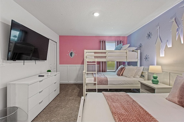 bedroom with dark colored carpet, a closet, and a textured ceiling