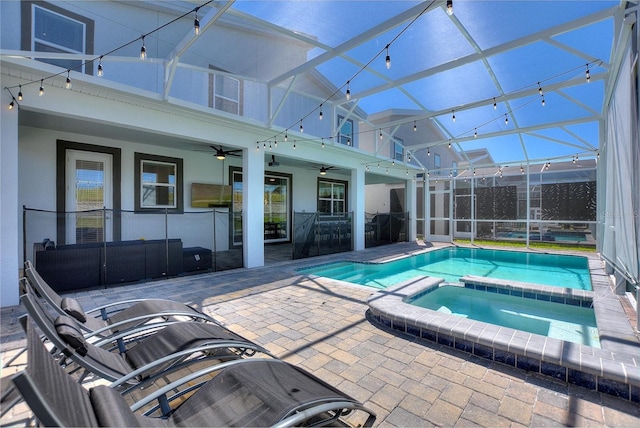 view of swimming pool featuring an in ground hot tub, a patio, a lanai, and ceiling fan