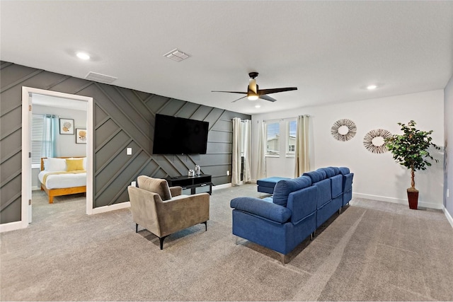 carpeted living room with ceiling fan