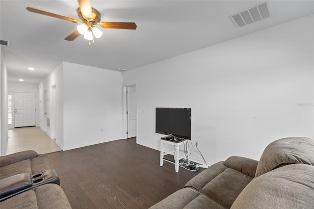 living room with ceiling fan and dark hardwood / wood-style flooring