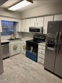 kitchen with white cabinetry, sink, and stainless steel appliances