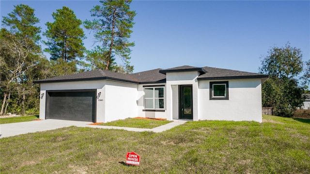 prairie-style home featuring a garage and a front lawn