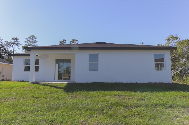 rear view of property featuring a yard