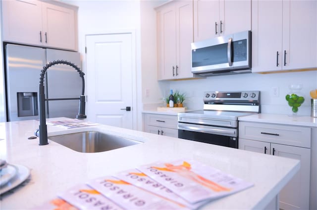 kitchen featuring white cabinetry, sink, and appliances with stainless steel finishes