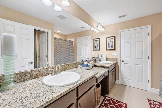 bathroom with tile patterned floors, visible vents, and a sink