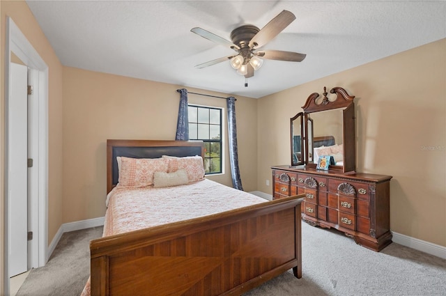 bedroom featuring baseboards, light carpet, and ceiling fan