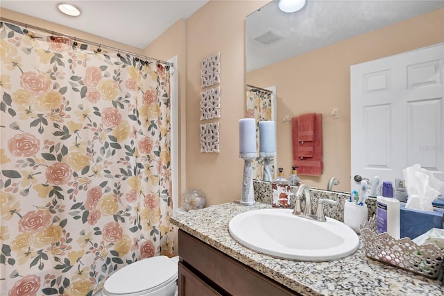 bathroom featuring vanity, a shower with shower curtain, and toilet