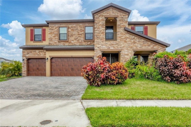 view of front facade with stucco siding, a front lawn, decorative driveway, stone siding, and a garage