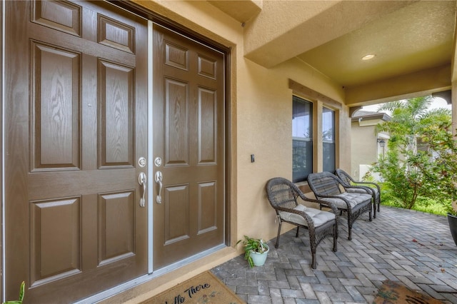 property entrance featuring stucco siding and a porch