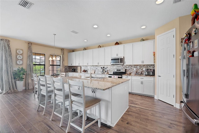 kitchen featuring tasteful backsplash, visible vents, dark wood finished floors, and stainless steel appliances