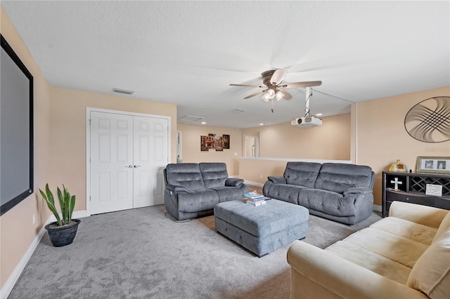 carpeted living area with visible vents, baseboards, and a ceiling fan