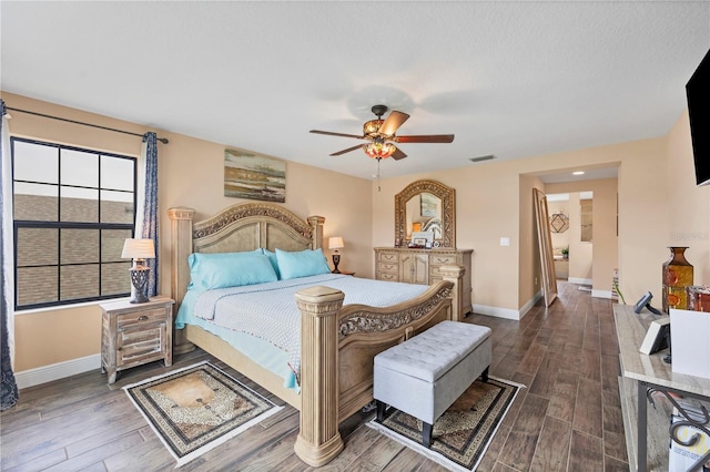 bedroom with ceiling fan, visible vents, baseboards, and dark wood-style floors