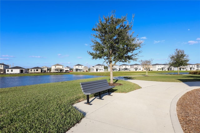 view of community with a yard, a residential view, and a water view