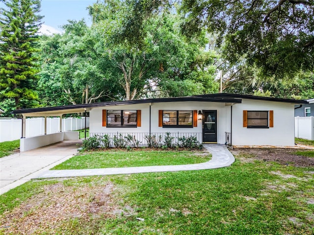 view of front facade with a carport and a front yard