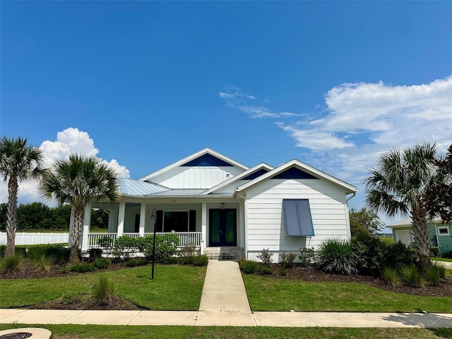 1077 Sugar Loaf Key Loop, Lady Lake, FL 32159 - view of front of property featuring covered porch, a front yard, a standing seam roof, french doors, and a metal roof