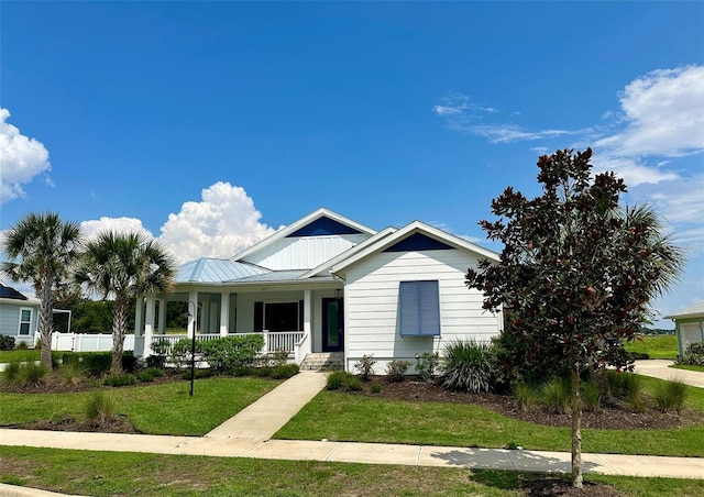 view of front facade featuring covered porch and a front yard