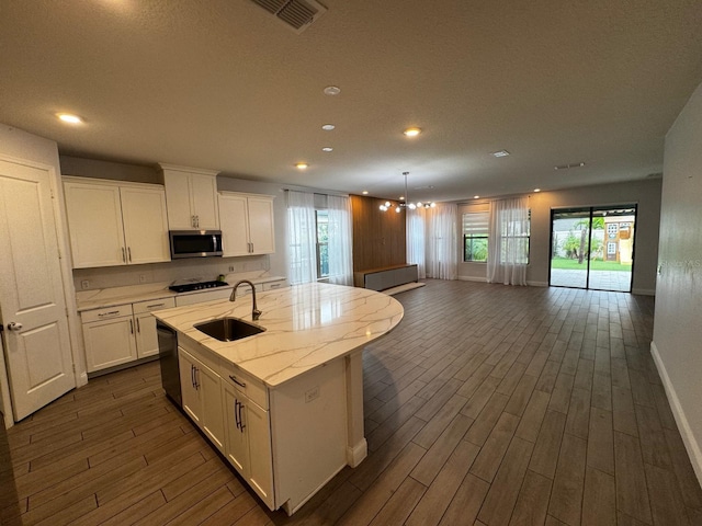 kitchen featuring white cabinetry, sink, a kitchen island with sink, and black appliances