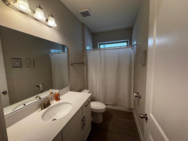 full bathroom featuring vanity, wood-type flooring, shower / bath combo with shower curtain, and toilet