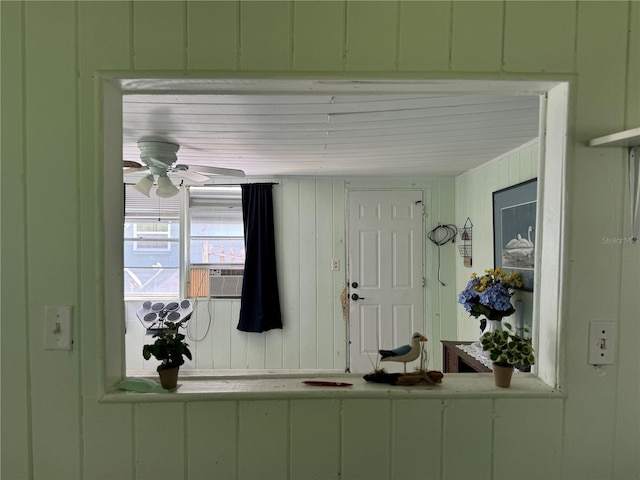 entrance foyer with cooling unit, wood walls, and ceiling fan