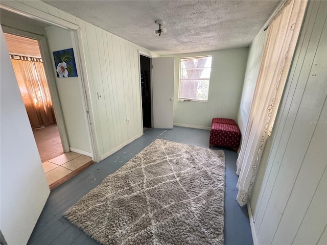 bedroom featuring a textured ceiling, a closet, and wooden walls