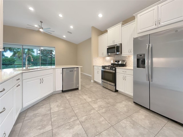 kitchen with sink, white cabinets, vaulted ceiling, and appliances with stainless steel finishes