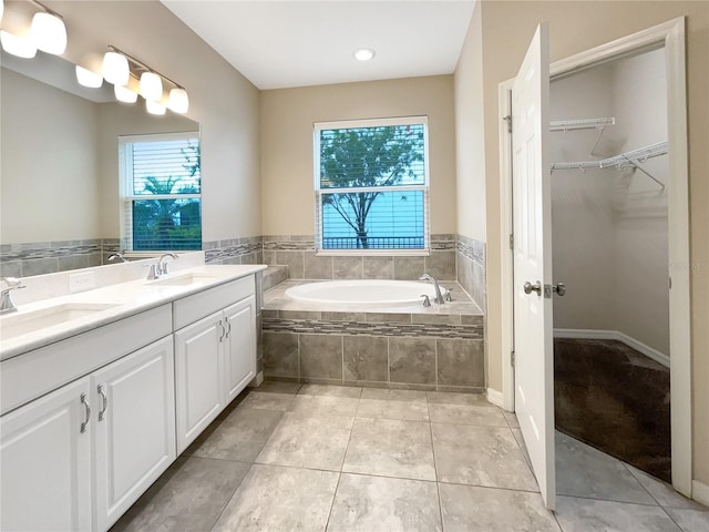 bathroom featuring tile patterned floors, tiled tub, and vanity