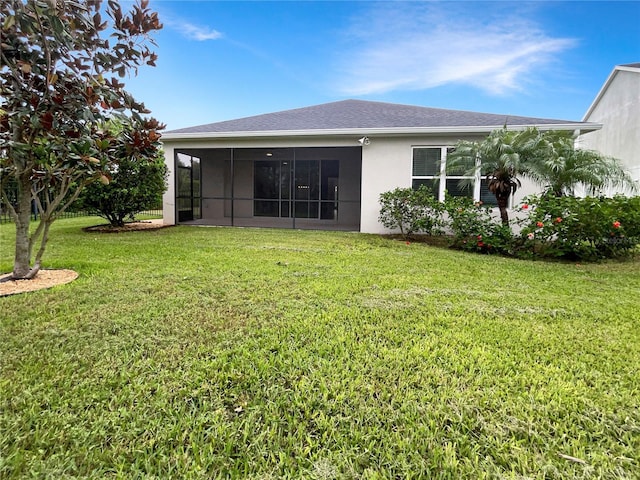 rear view of property with a yard and a sunroom