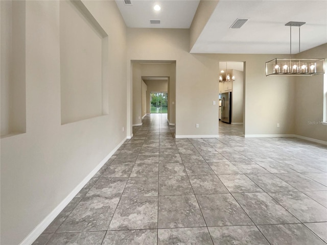 unfurnished room featuring a notable chandelier