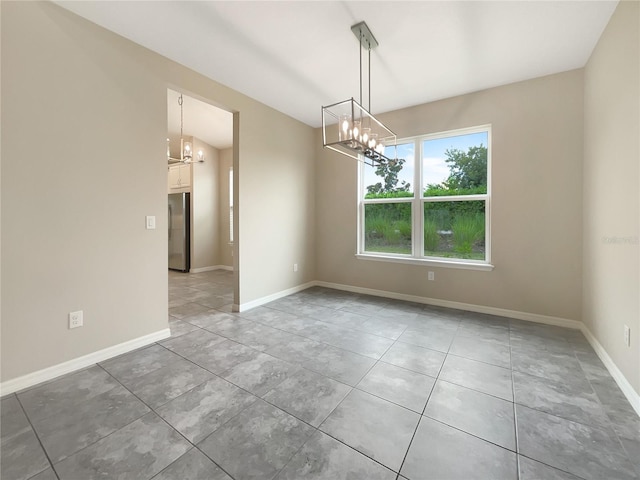 tiled spare room featuring an inviting chandelier and vaulted ceiling