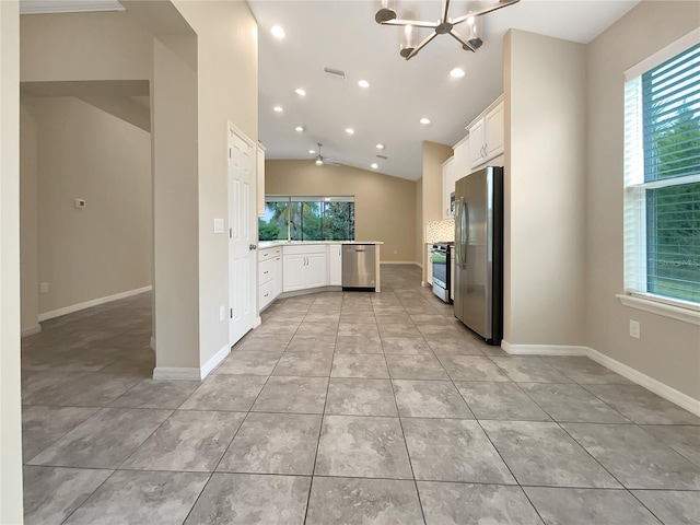 kitchen featuring white cabinets, stainless steel appliances, a healthy amount of sunlight, and lofted ceiling