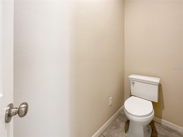 bathroom with toilet and tile patterned flooring