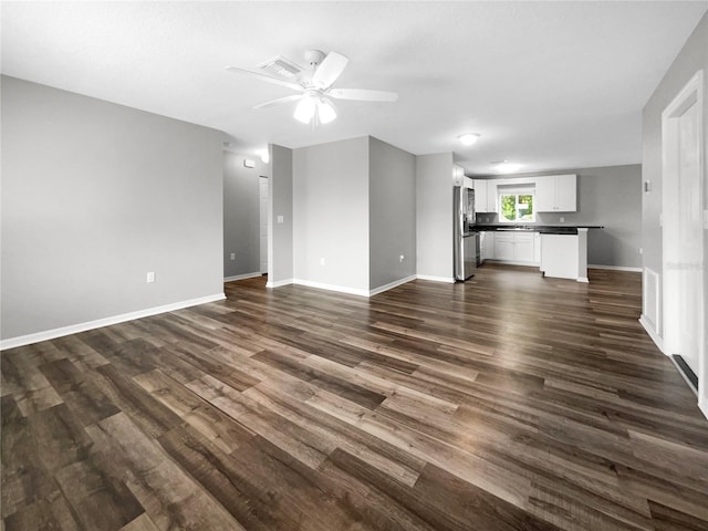 unfurnished living room with ceiling fan and dark hardwood / wood-style flooring