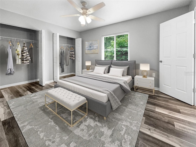 bedroom with two closets, ceiling fan, and dark hardwood / wood-style floors