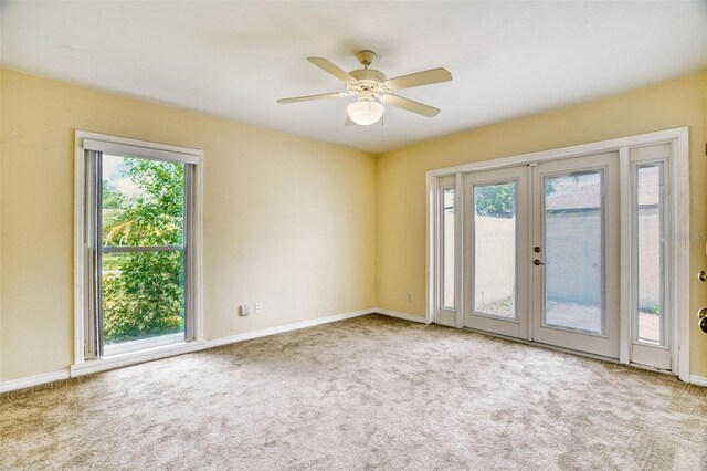 carpeted empty room with ceiling fan and french doors