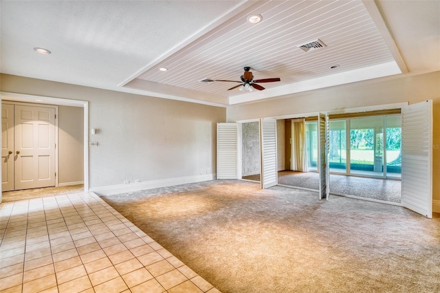 interior space featuring a raised ceiling, ceiling fan, and wood ceiling