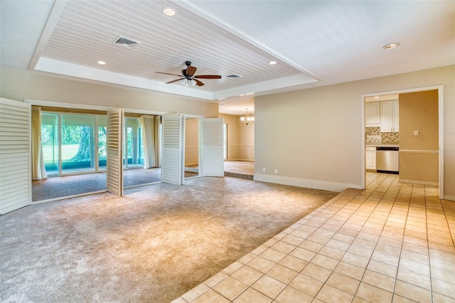 unfurnished living room with a raised ceiling, ceiling fan with notable chandelier, light colored carpet, and wooden ceiling