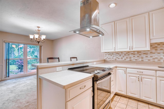 kitchen featuring stainless steel electric range, decorative light fixtures, kitchen peninsula, and island exhaust hood