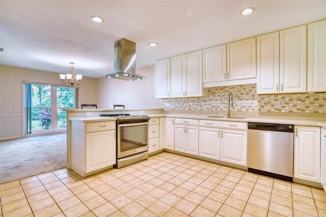 kitchen featuring appliances with stainless steel finishes, pendant lighting, sink, island exhaust hood, and light carpet