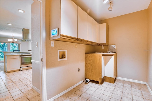 washroom featuring electric dryer hookup, washer hookup, track lighting, and light tile patterned floors