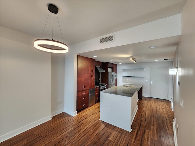 kitchen with white cabinets, sink, dark hardwood / wood-style floors, an island with sink, and appliances with stainless steel finishes