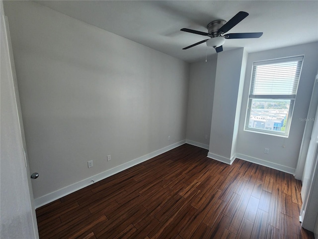 empty room with dark hardwood / wood-style flooring and ceiling fan