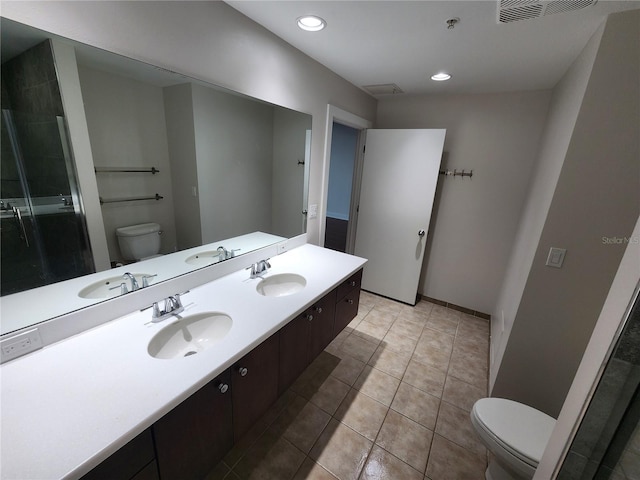 bathroom with tile patterned floors, vanity, toilet, and a shower with shower door