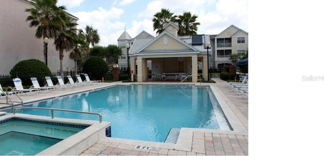 view of pool featuring a hot tub and a patio area