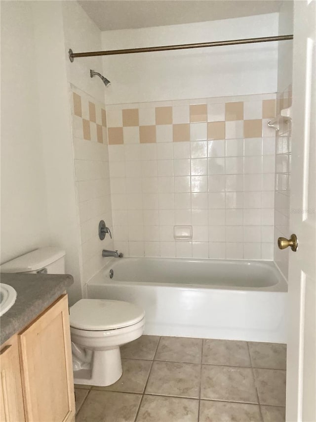 full bathroom featuring tile patterned flooring, vanity, tiled shower / bath combo, and toilet