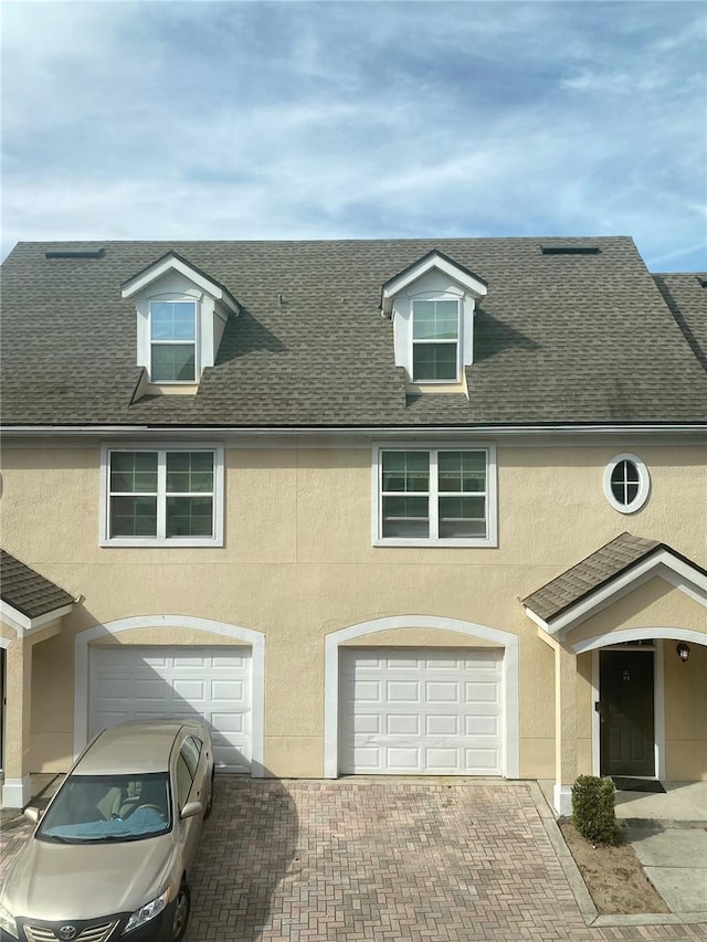 view of front of house with stucco siding, an attached garage, and driveway